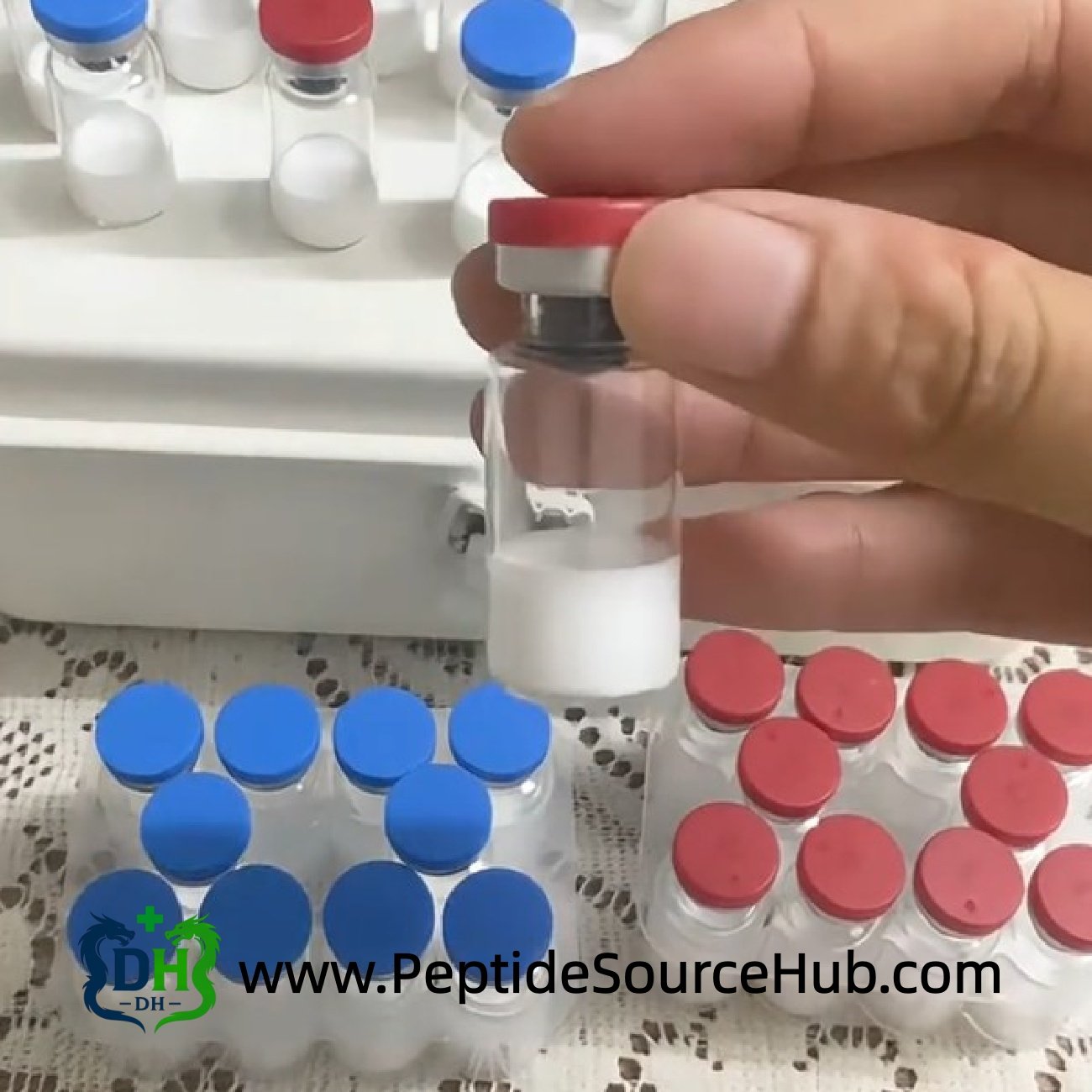 Hand holding a peptide vial, tray kits in background