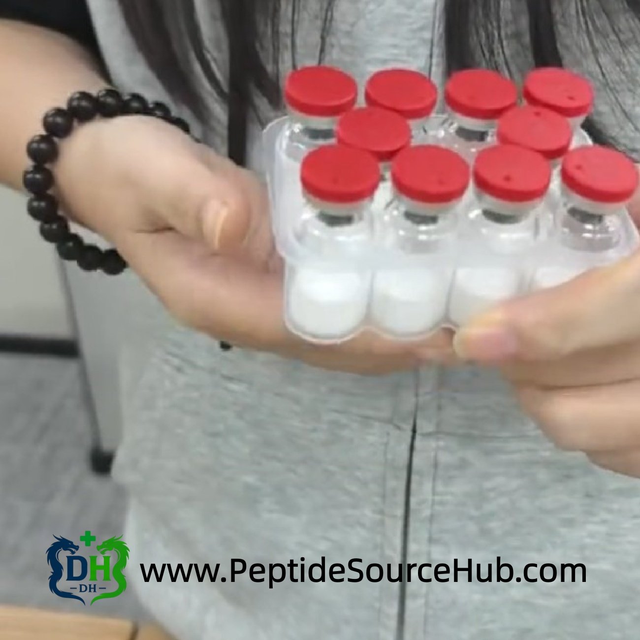Hands holding tray of red-cap Follistatin-344 peptide vials