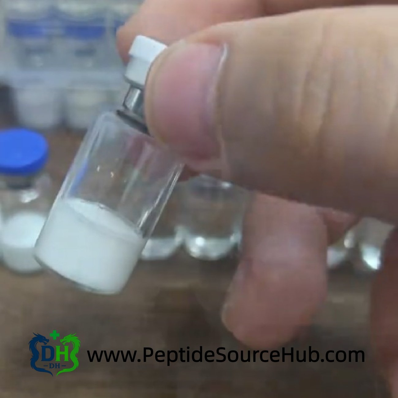Hand holding Oxytocin Acetate vial with white powder