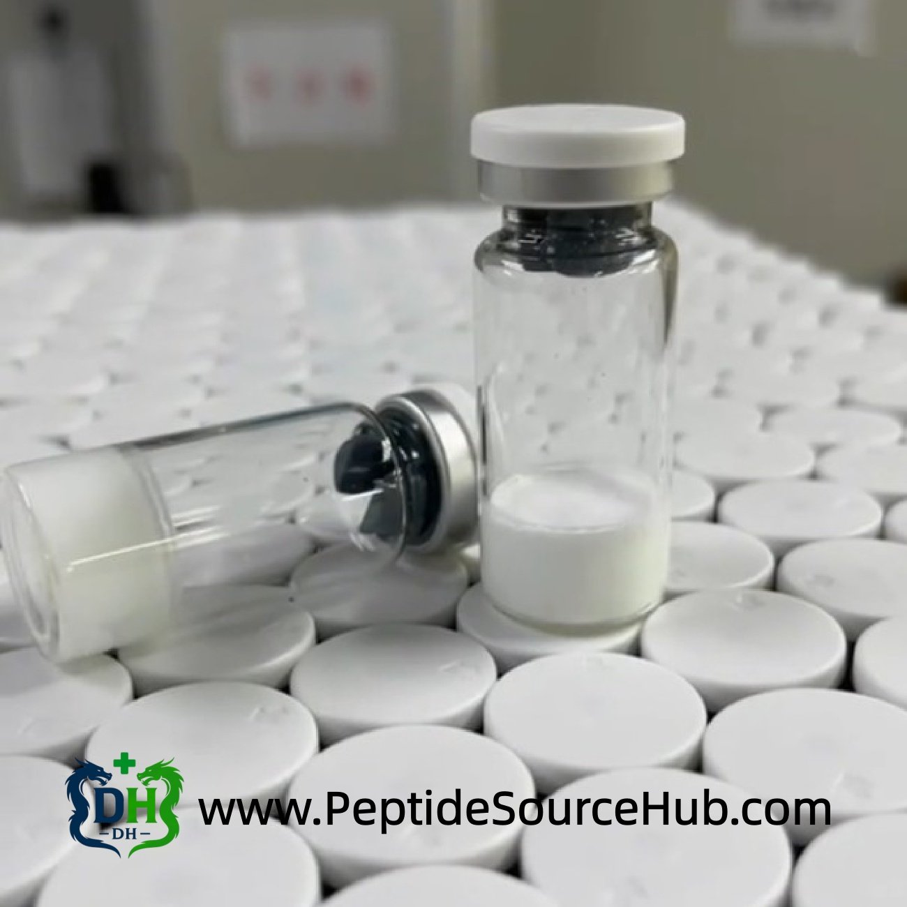 Two Oxytocin Acetate vials standing on tray of caps