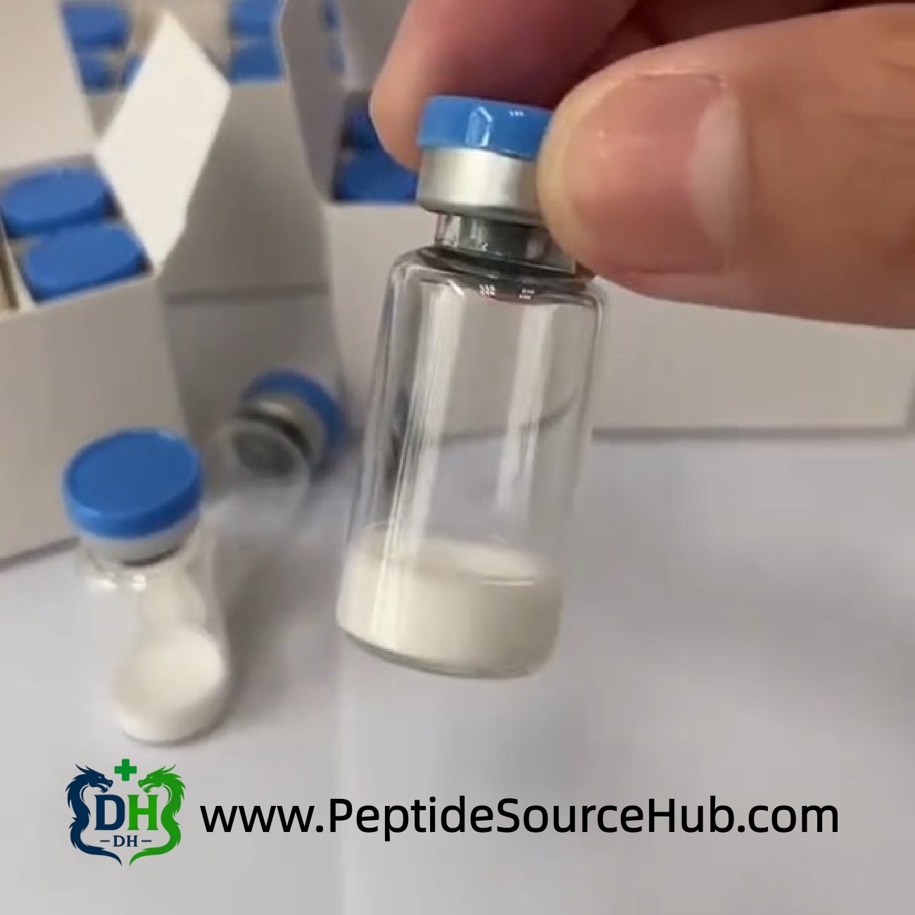 Hand holding blue-cap peptide vial close-up