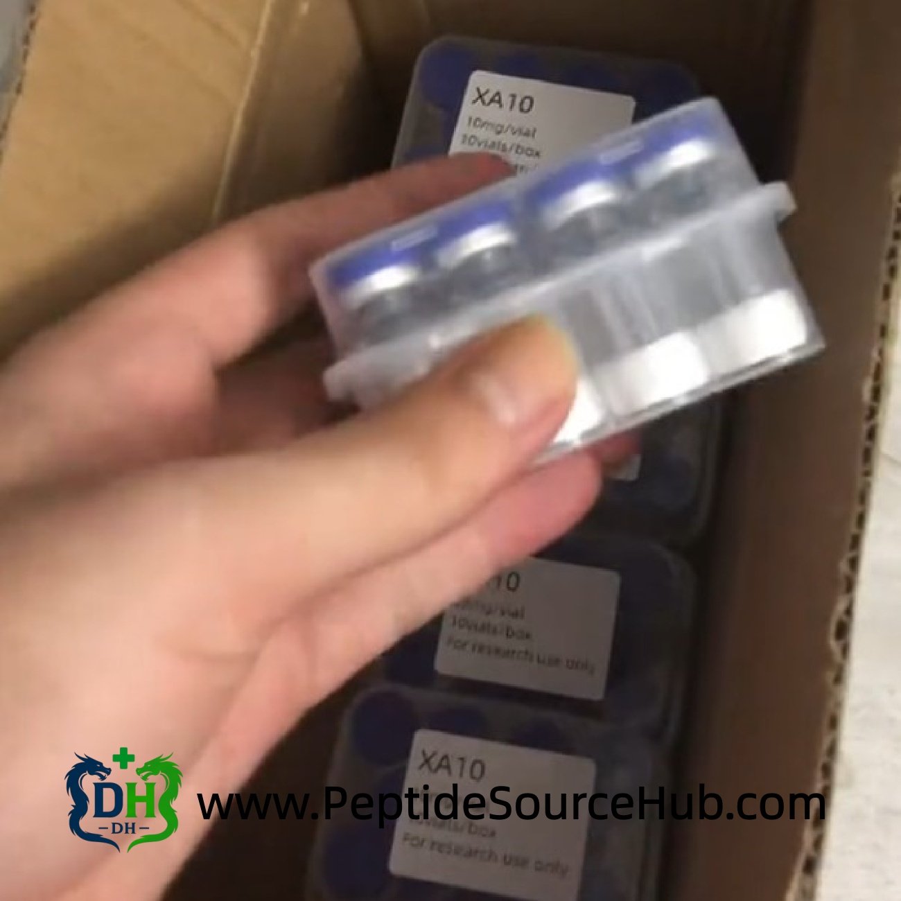 Hand holding boxed peptide vial kit from carton