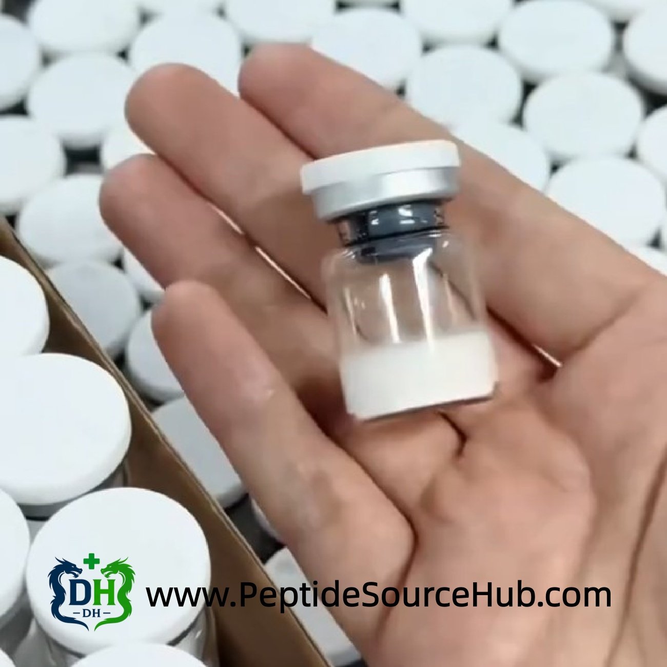 Hand holding a single peptide vial with white cap