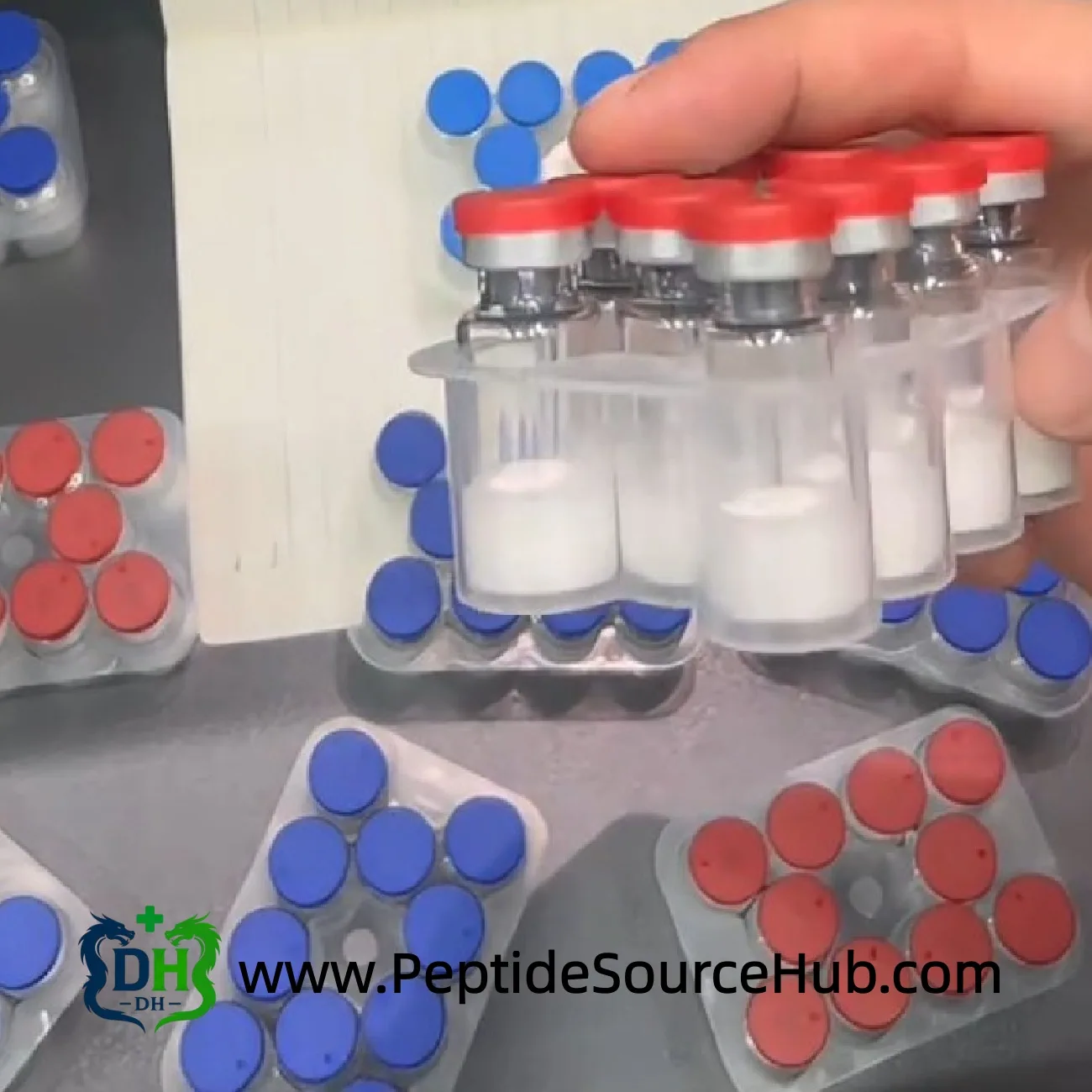 Red cap peptide tray held above multiple trays