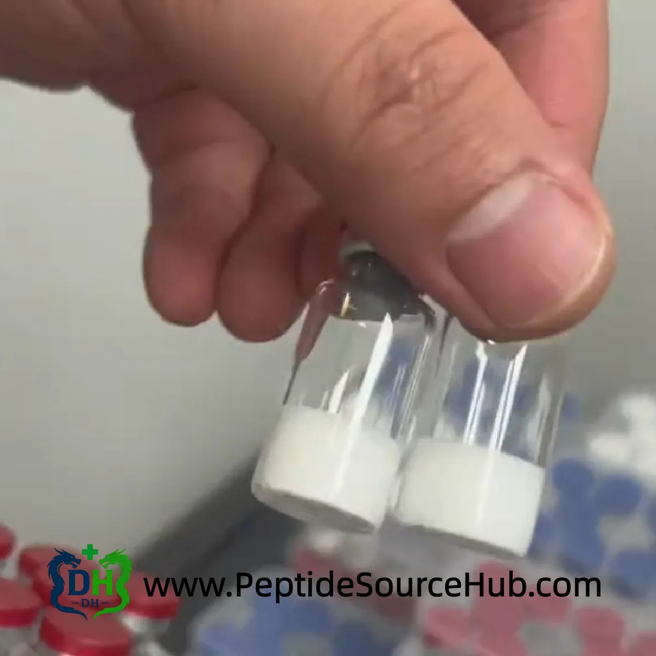 Two lyophilized peptide vials held by hand