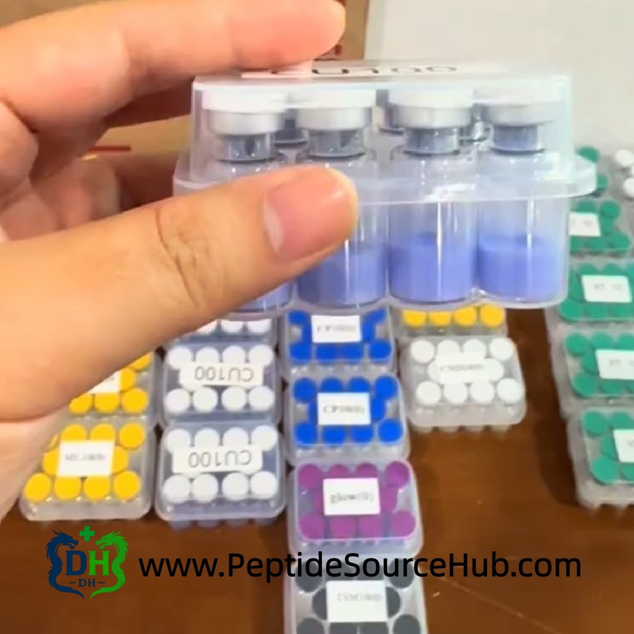 White-cap tray of blue copper peptide vials above mixed trays