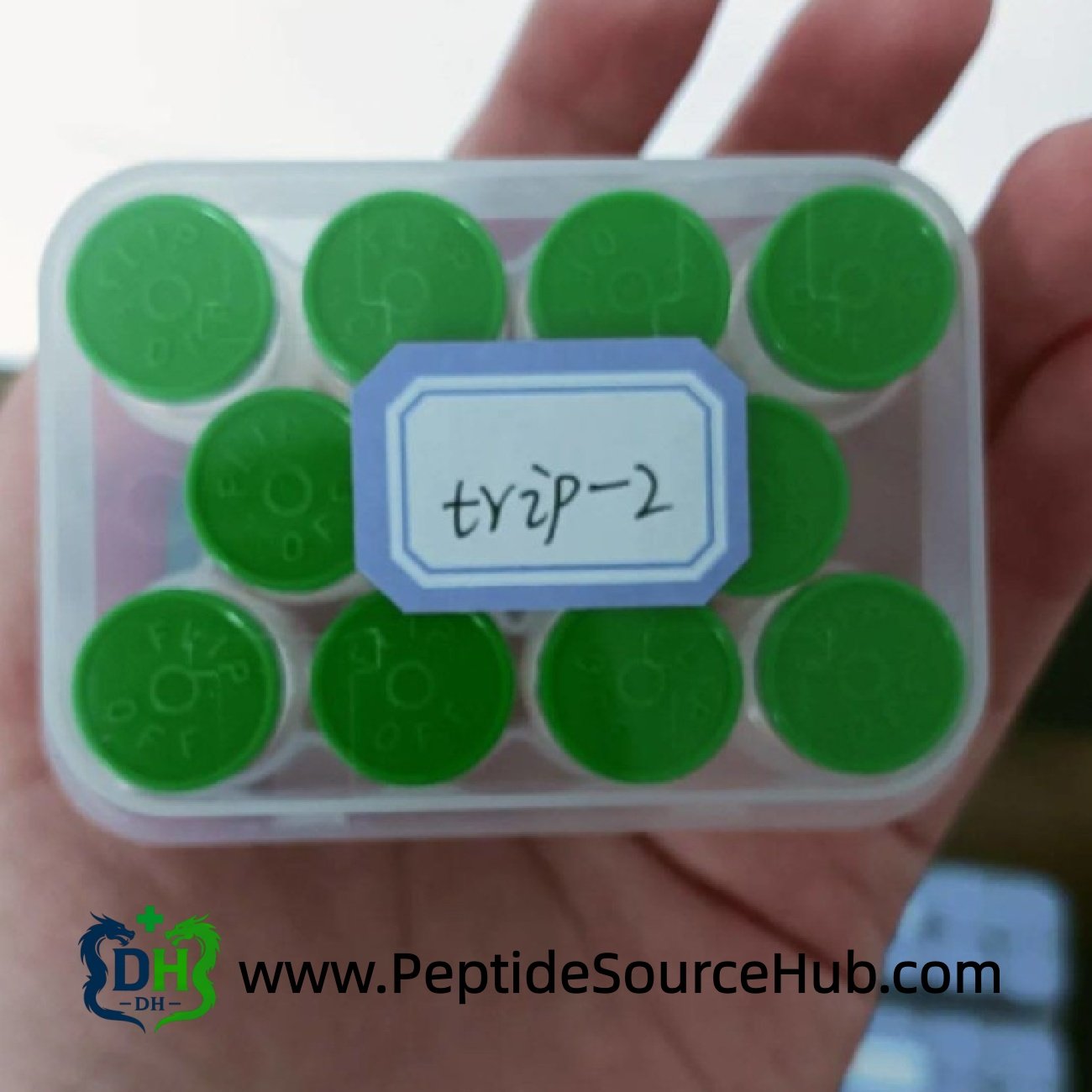 Hand holding plastic tray of green cap Triptorelin 2 mg vials