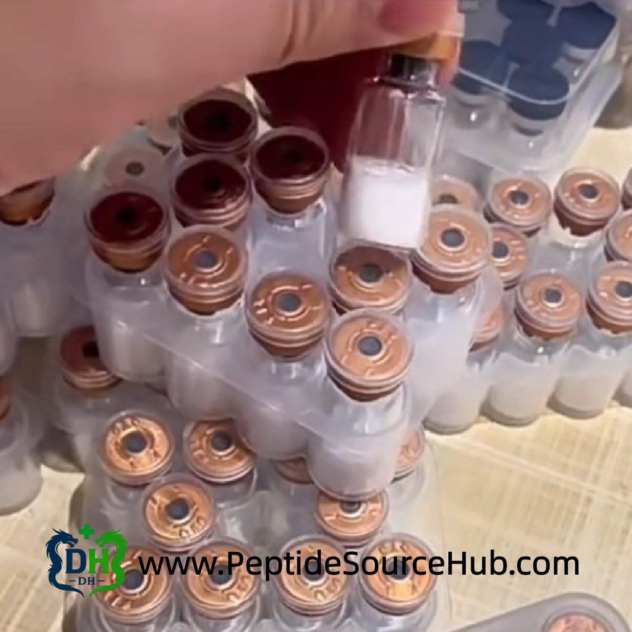 Hand lifting bronze cap peptide vial from stacked trays