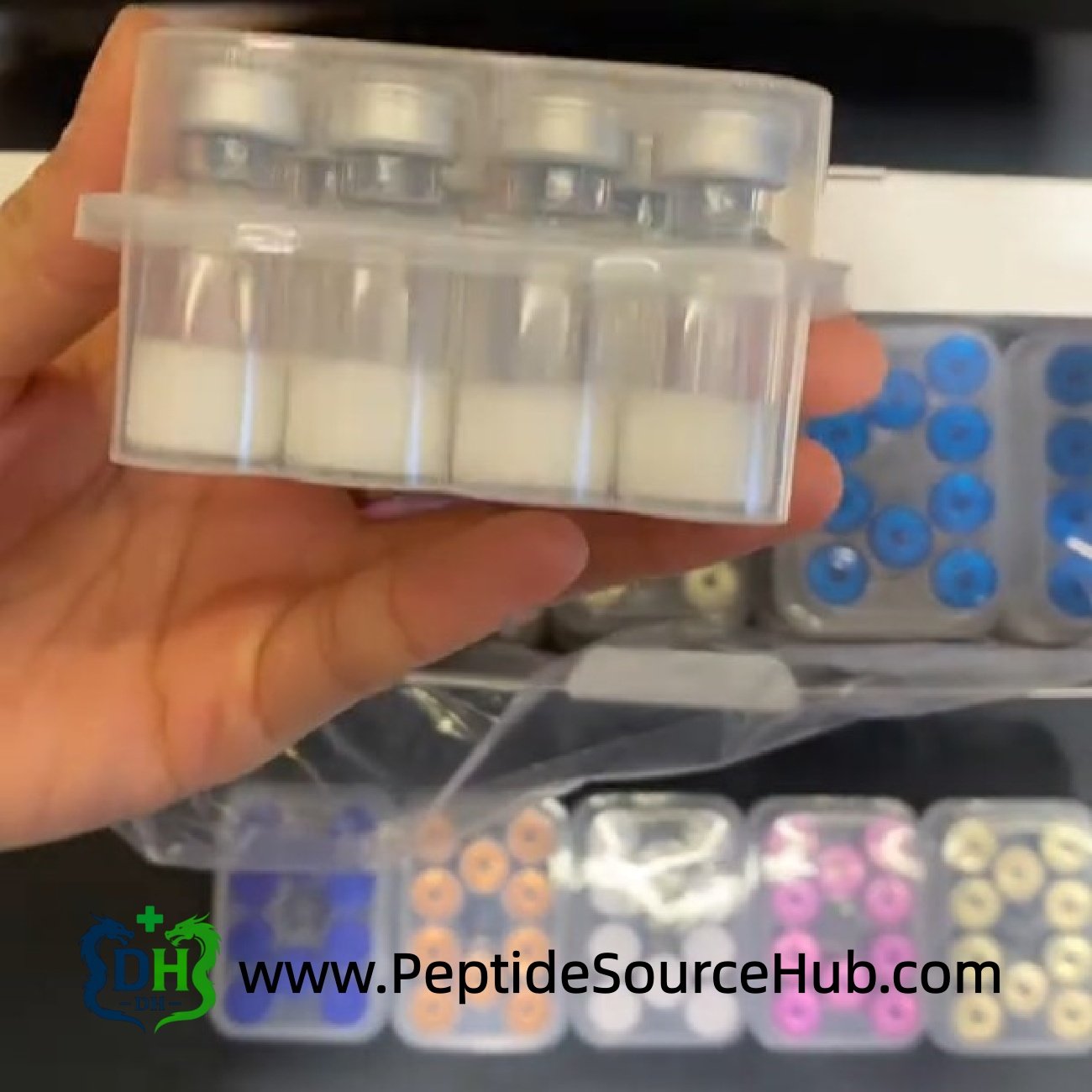 Hand holding clamshell tray of VIP peptide vials